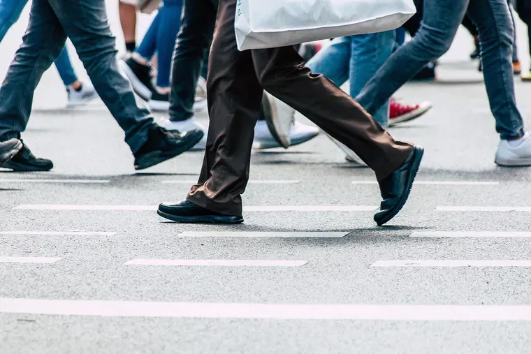 Jambes de piétons qui traversent une rue sur un passage marqué au sol